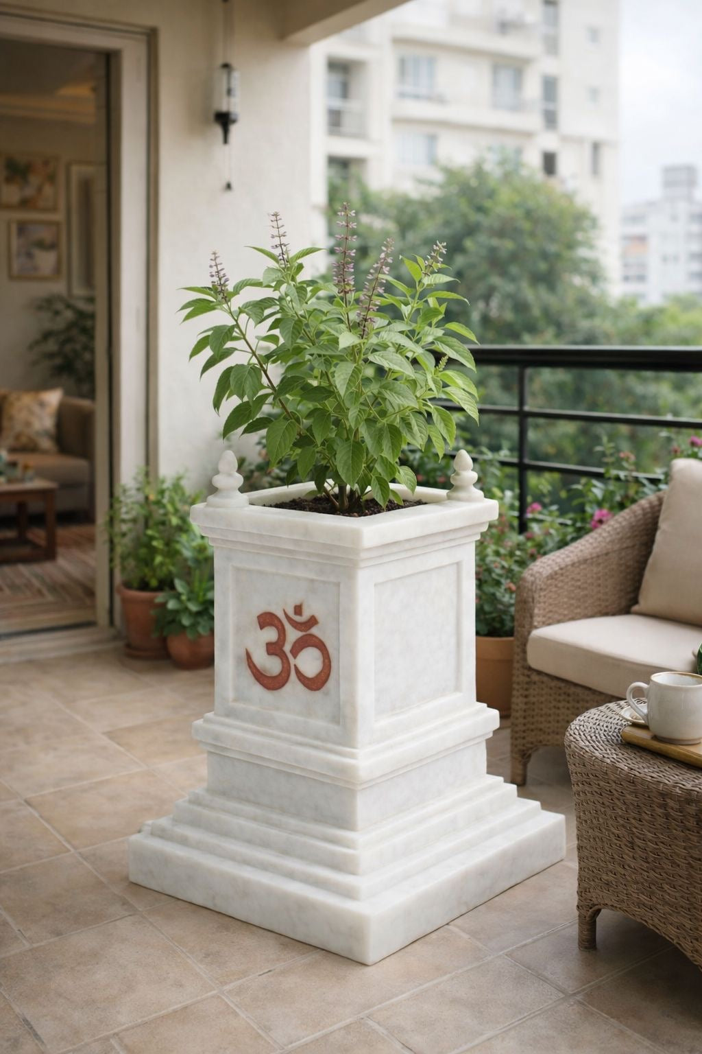 White planter with green plants on a balcony with a building in the background